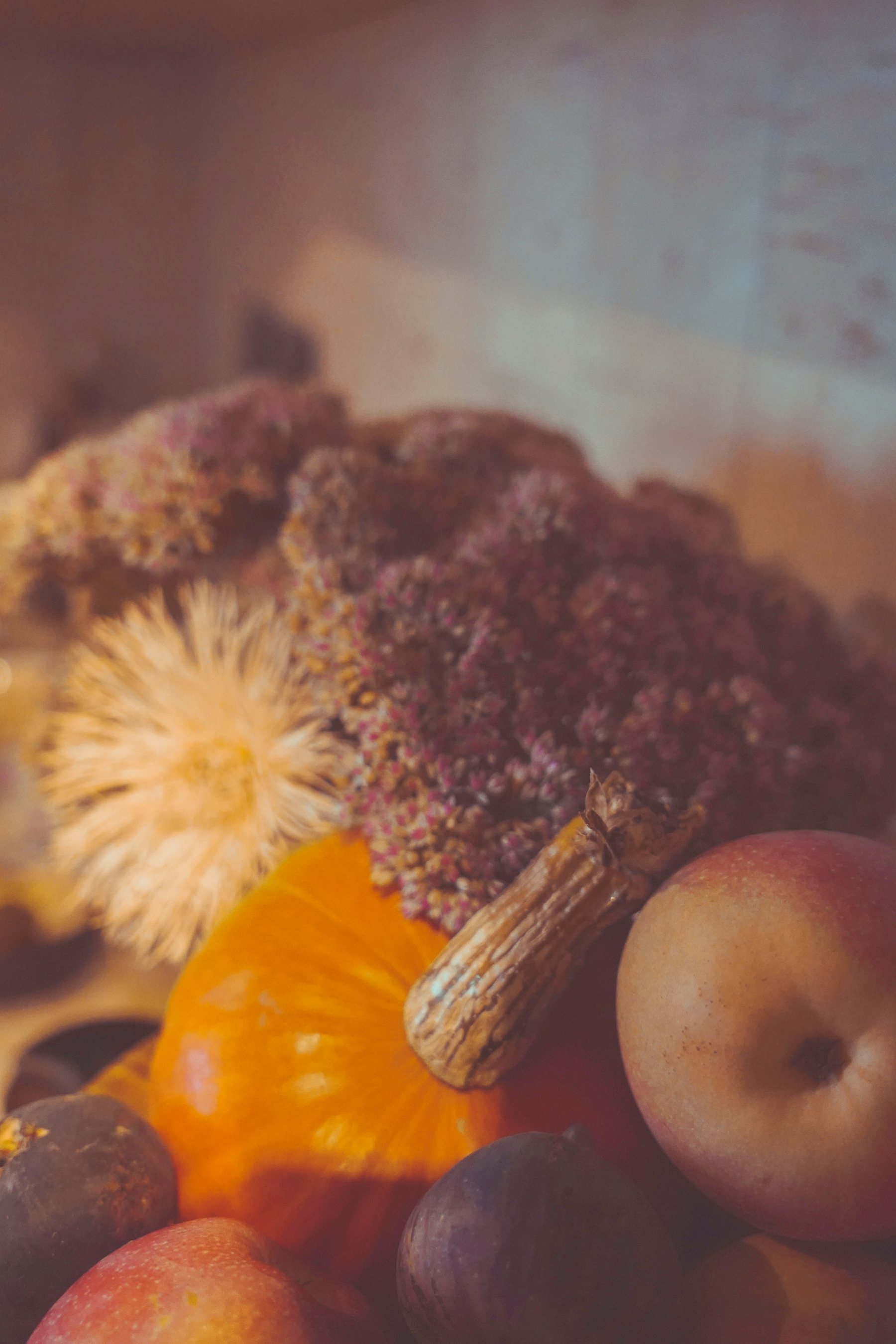 Autumn harvest still life — pumpkin, figs, apple and dried flowers
